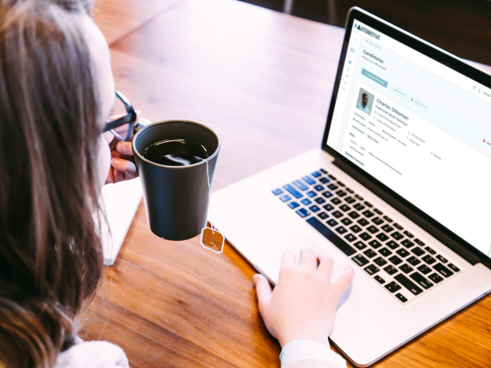 Lady sat at her laptop with a cup of coffee in her hand